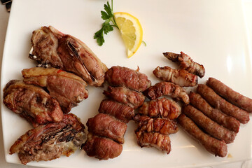 Mixed roast meat. Lamb, gnummareddi or torcinelli, rolls based on lamb offal, sausage and the famous bombette martinesi, meat rolls stuffed with cheese. Italian food