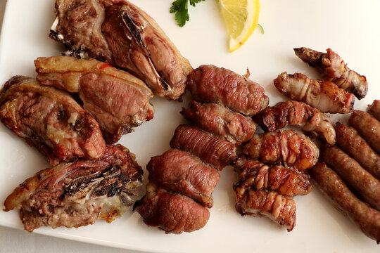 Mixed roast meat. Lamb, gnummareddi or torcinelli, rolls based on lamb offal, sausage and the famous bombette martinesi, meat rolls stuffed with cheese. Italian food
