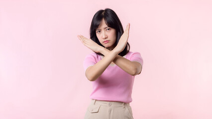 portrait serious young asian woman with cross arm gesture showing stop, no, wrong, denial,...