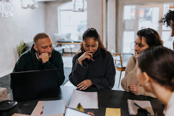 Multiracial colleagues planning business strategy at desk in startup company