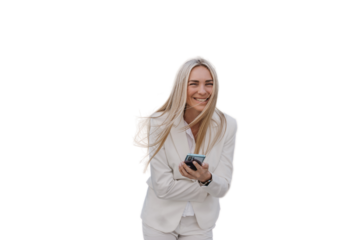 Excited young blonde businesswoman in white suit holds phone laughing standing outside against transparent background. smiles. Cheerful caucasian female manager received great news.