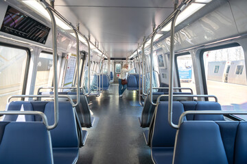 Blonde adult woman in an empty Washington subway train wearing blue jeans while waving her hand out...