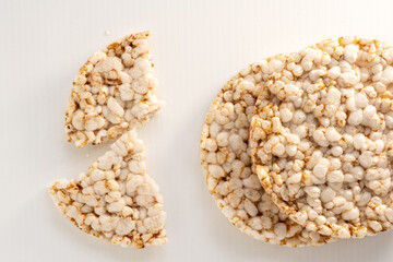 Closeup of a round rice cakes made from wholegrain brown rice, a low calorie healthy snack on a white background. Top view.