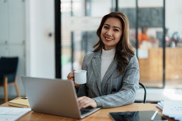 Fototapeta premium Portrait of a business woman talking on the phone and drinking coffee