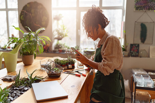 Professional florist taking picture of her plants for publishing in social media. Blurred background