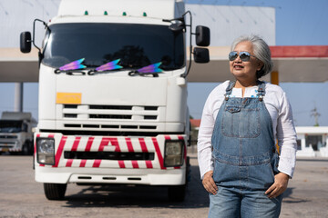 Business owner standing in front of oil truck after performing a pre-trip inspection on a truck....