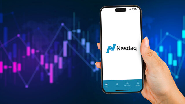 Female hand holding a smartphone iPhone 14 Pro with Nasdaq Stock Exchange app on the screen. Graphic in the background. Rio de Janeiro, RJ, Brazil. March 2023