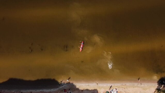Aerial view of adventurous family river kayaking together near the shore with sunset light, leisure, kayaking tourism