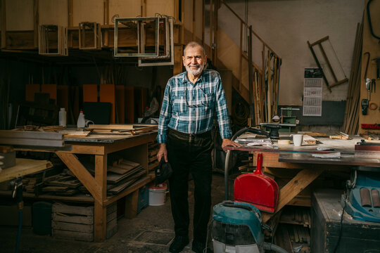 Senior craftsman standing near workbench at carpentry workshop