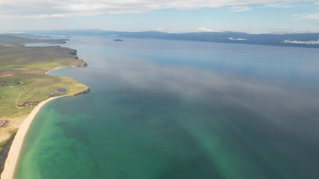 Lake Baikal on a windless summer day. Beautiful water color. Olkhon Island. A popular tourist destination for vacations and travel. 4k footage