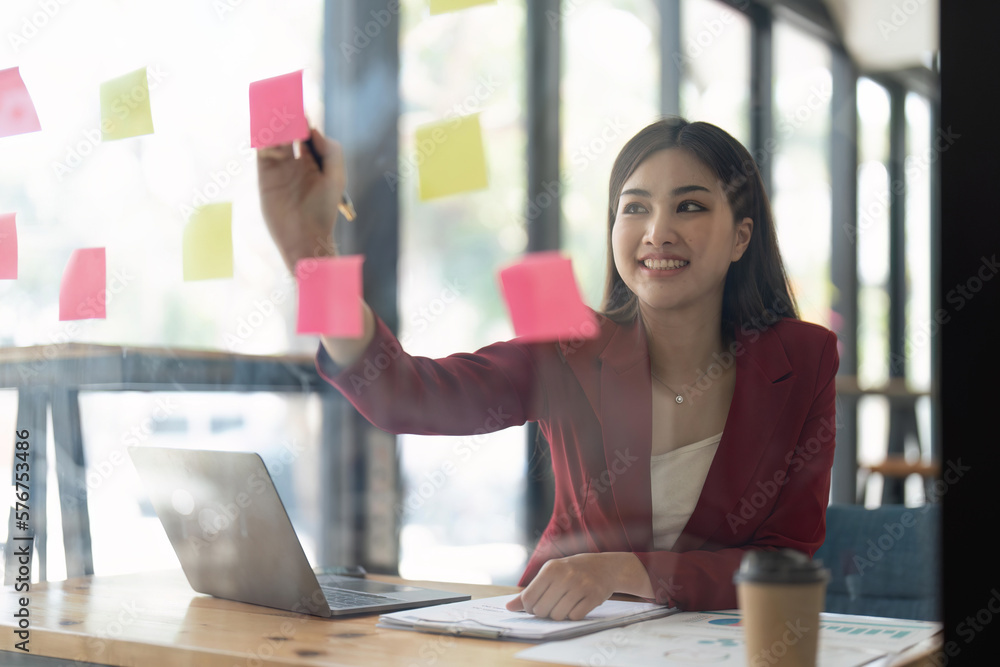 Aufkleber a woman using a sticky note and analysis data report during writing make note some data on notepad, 