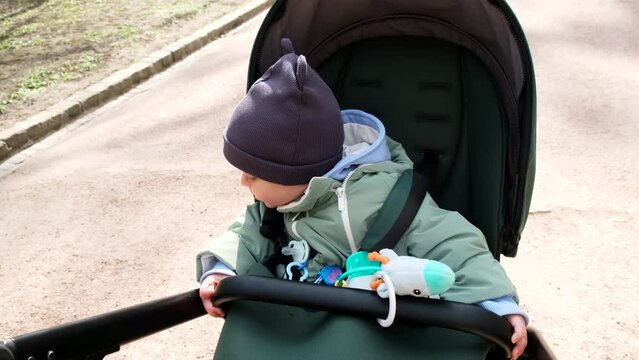 little cute toddler boy in stroller outdoors