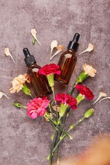 Dropper glass bottles Mock-Up among flowers. Liquid pipettes oil or serum elixir, hyaluronic acid bakuchiol. Beauty treatment