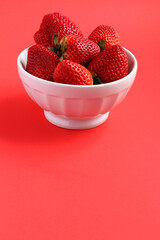 Fresh strawberries in a white antique bowl, wuth space for text.