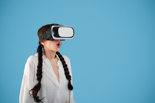 Glad surprised teen european girl student with pigtails in vr glasses look at copy space - Powered by Adobe