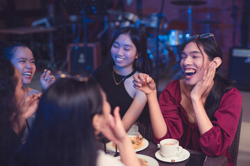 Five young women took a night out as they celebrate their years of friendship. Ladies laugh at a joke being shared by a friend over dinner. Keeping a small friendship circle.