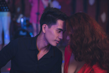 Naklejka premium An affectionate couple presses their foreheads against each other and while looking eye to eye. Boyfriend and girlfriend feeling the sexual tension. Unspoken erotic body language.