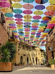 Street decorated with colored umbrellas. Poble Espanyol de Montjuic traditional architectures in Barcelona, Catalonia, Spain