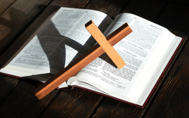 wooden cross and bible on wooden background