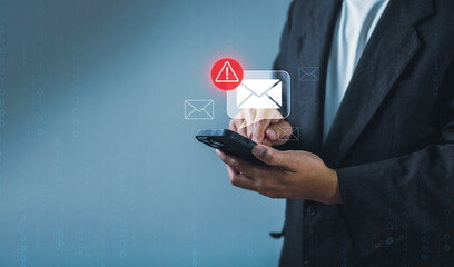 Businessman using smartphone with electronic email hacking and spam warning symbol. cyber attack network, virus, spyware, Cyber security and cybercrime