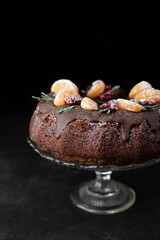 Blurred image of a chocolate cupcake decorated with fruits on a dark background.