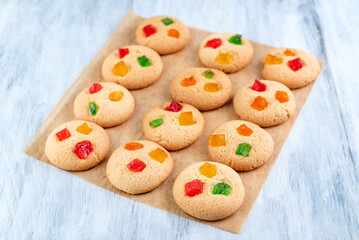 Homemade cookies with candied fruit on paper on the table.