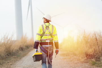 Male engineer wearing uniform, helmet and holding equipment tools while walking survey the land...