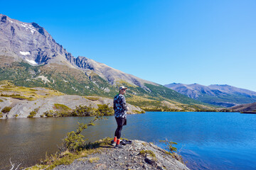 mature man hiker contemplating the beauty of mountains and lake in Torres del Paine National Park Chile