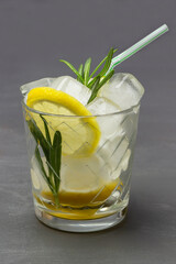 Summer drink with lemon and ice. Straw in a glass.
