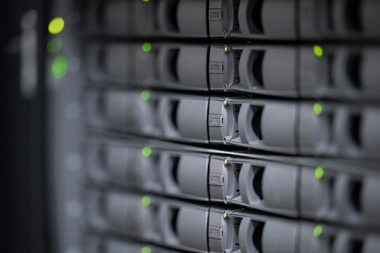 depth of field of gray disk slots of an it network attached storage device with green LEDs