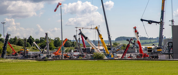 Panoramic view of many different truck cranes in the parking yard