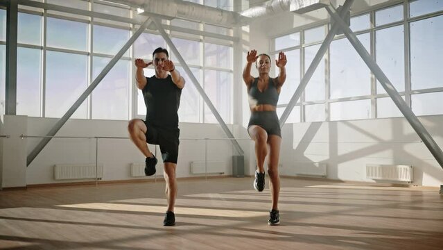 Young determined athletic couple jumping up in the place for warm-up. Sport Workout Fitness