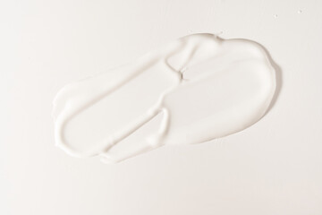 A white cosmetic smear on an isolated white background. Sample for advertising and packaging. The texture of a white face cream. Cosmetic skin care product with space to copy. High quality photo