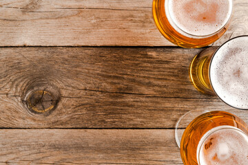 Overhead shot of beer glasses on wooden table.