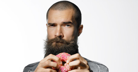 Brutal guy with donut in his hands on gray background. The concept of vigor and recuperation....