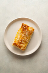 Puff pastry dough. Folded baked puff pastry pie in a plate.