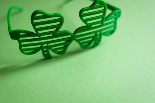 St. Patrick 's Day. glasses in form of clover leaves on a green background with copy space