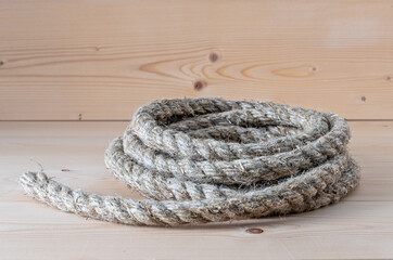 Jute rope rolled into a bay on a wooden table, workbench.