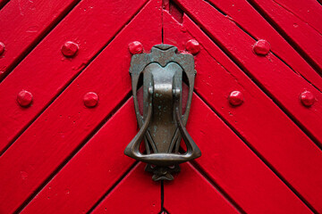 antique door lock on the background of old red doors