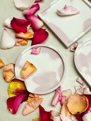 Fototapeta na wymiar Concrete pink marbled trays trays with roses' petals