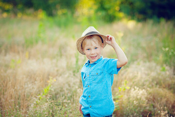 Little boy enjoying life and nature. Happy Kid on summer field . Fresh air, environment concept.