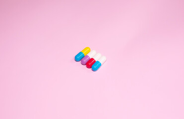 Pills isolated on pink background. The concept of medicine, health insurance or pharmacy.