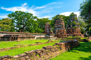 Fototapeta na wymiar Ruins of ancient city and temples Ayutthaya, Thailand. Old kingdom of Siam. Summer day with blue sky. Famous tourist destination, spiritual place near Bangkok.