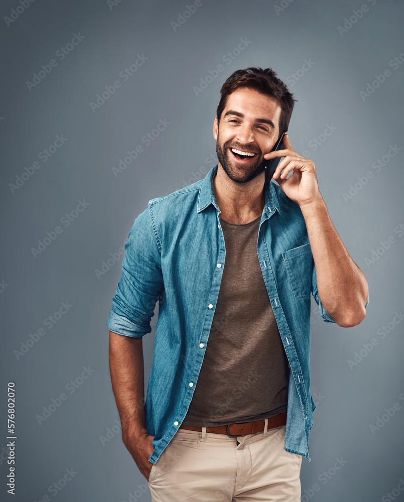 Poster Connecting with others keeps us happy. Studio shot of a handsome young man using a mobile phone against a grey background.