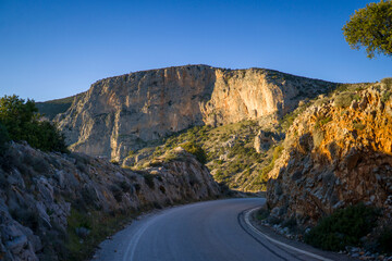 Road in the mountains at sunset among the coast.