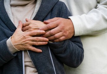 Man is holding hands of his beloved woman, closeup view.