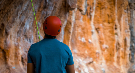 Naklejka premium A rock climber prepares for the training in the mountains.