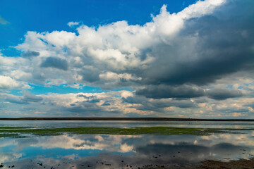 Reflection of white storm clouds in the water of the Tiligul estuary, Ukraine