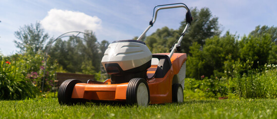A lawnmower at the meadow, in the backyard lawn.
