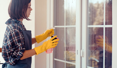 Young girl washes the windows.